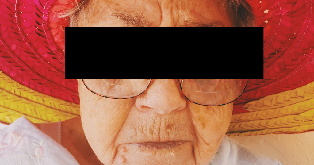 Eine ältere Dame mit einem schwarzen Balken vor den Augen