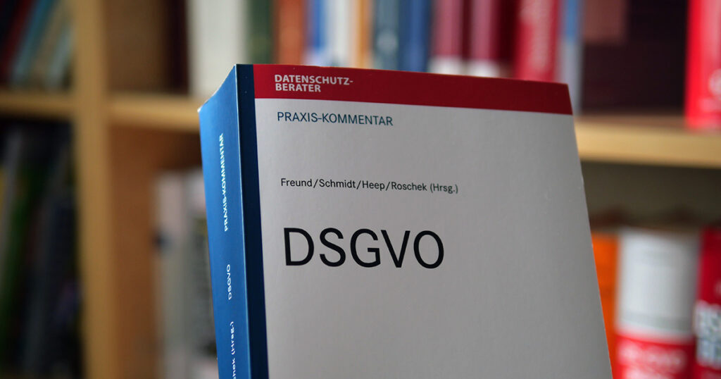 Titelseite des Praxiskommentars DSGVO vor einem Bücherregal