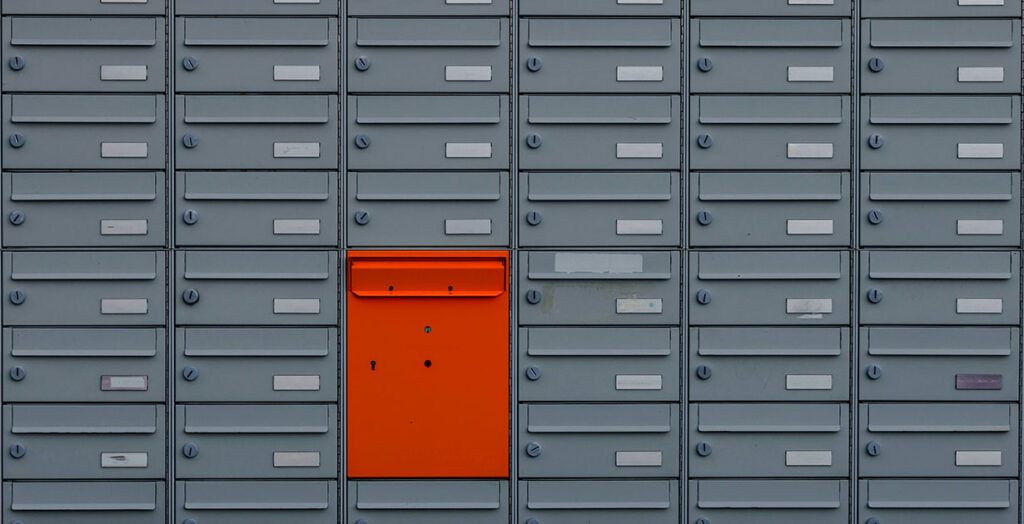 Roter Briefkasten in einer großen Briefkastenanlage